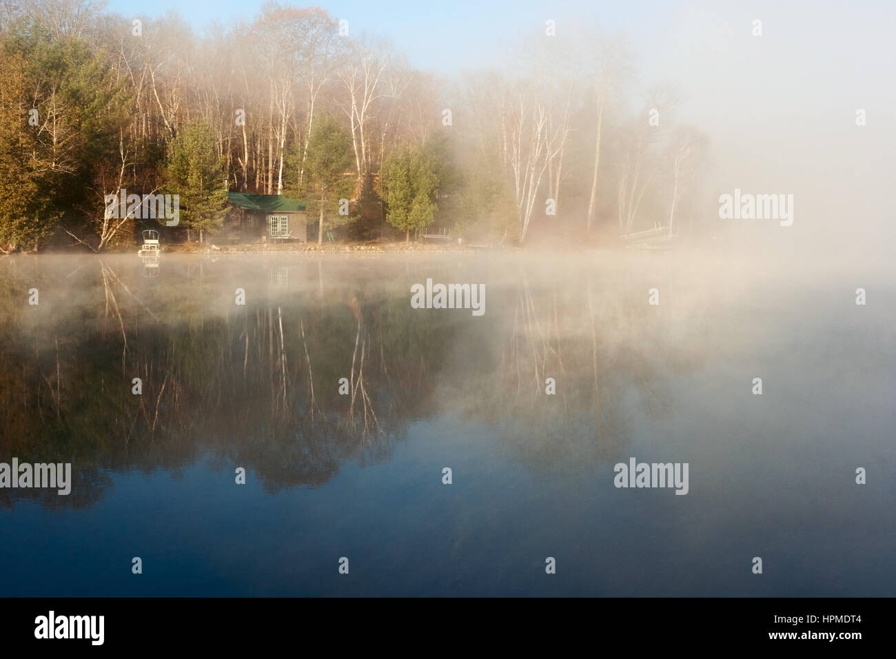 Tranquillo Lago misty con casa nella mattina di autunno Foto Stock