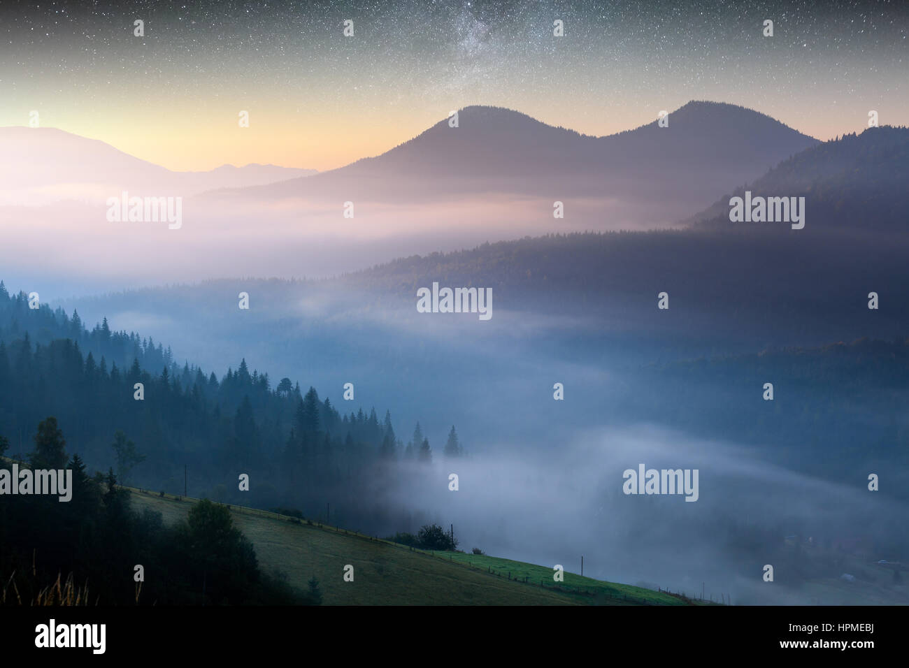 Bellissimo paesaggio di nebbia in montagna. Mattina fantastica incandescente dalla luce del sole. Foto Stock