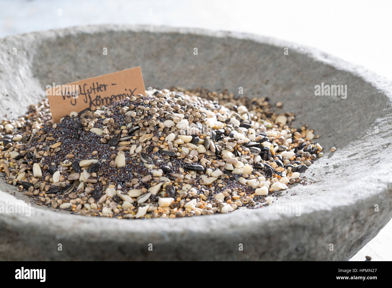 Selbstgemachtes Vogelfutter, Vogelfutter-Körnermix, Körnermischung, Zutaten Hanfsamen, Erdnussbruch, Hirse, Sonnenblumenkerne, Futter-Rosinen, Mohnsaa Foto Stock