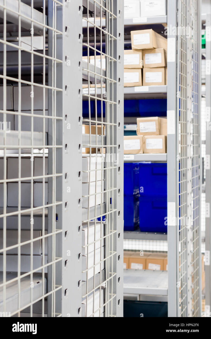 I contenitori di stoccaggio e industriali rack di stoccaggio in un magazzino shot con messa a fuoco poco profonda Foto Stock