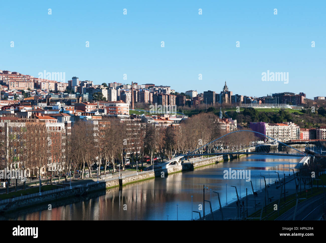 Spagna: skyline di Bilbao e fiume Nervion con vista del Zubizuri, il ponte bianco o il Campo Volantin Bridge da Santiago Calatrava Foto Stock