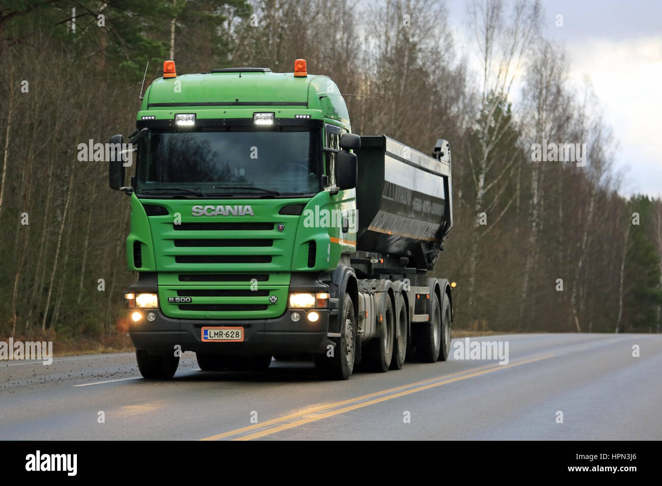 SALO, Finlandia - 23 dicembre 2016: Verde Scania R500 ribaltabile carrello si muove lungo la strada fiancheggiata da foresta. Foto Stock