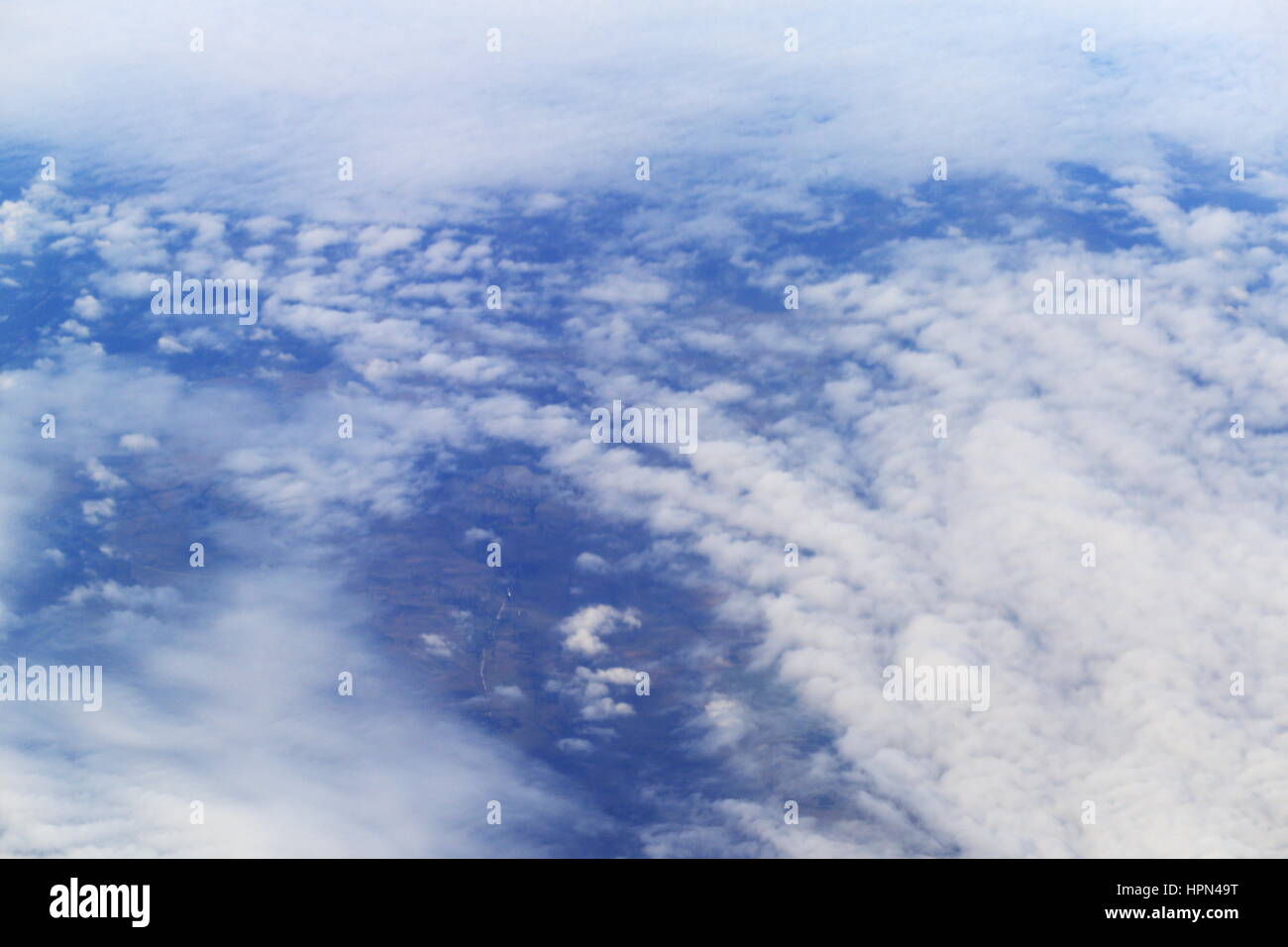 Vista sulla terra attraverso nuvole bianche dal piano Foto Stock