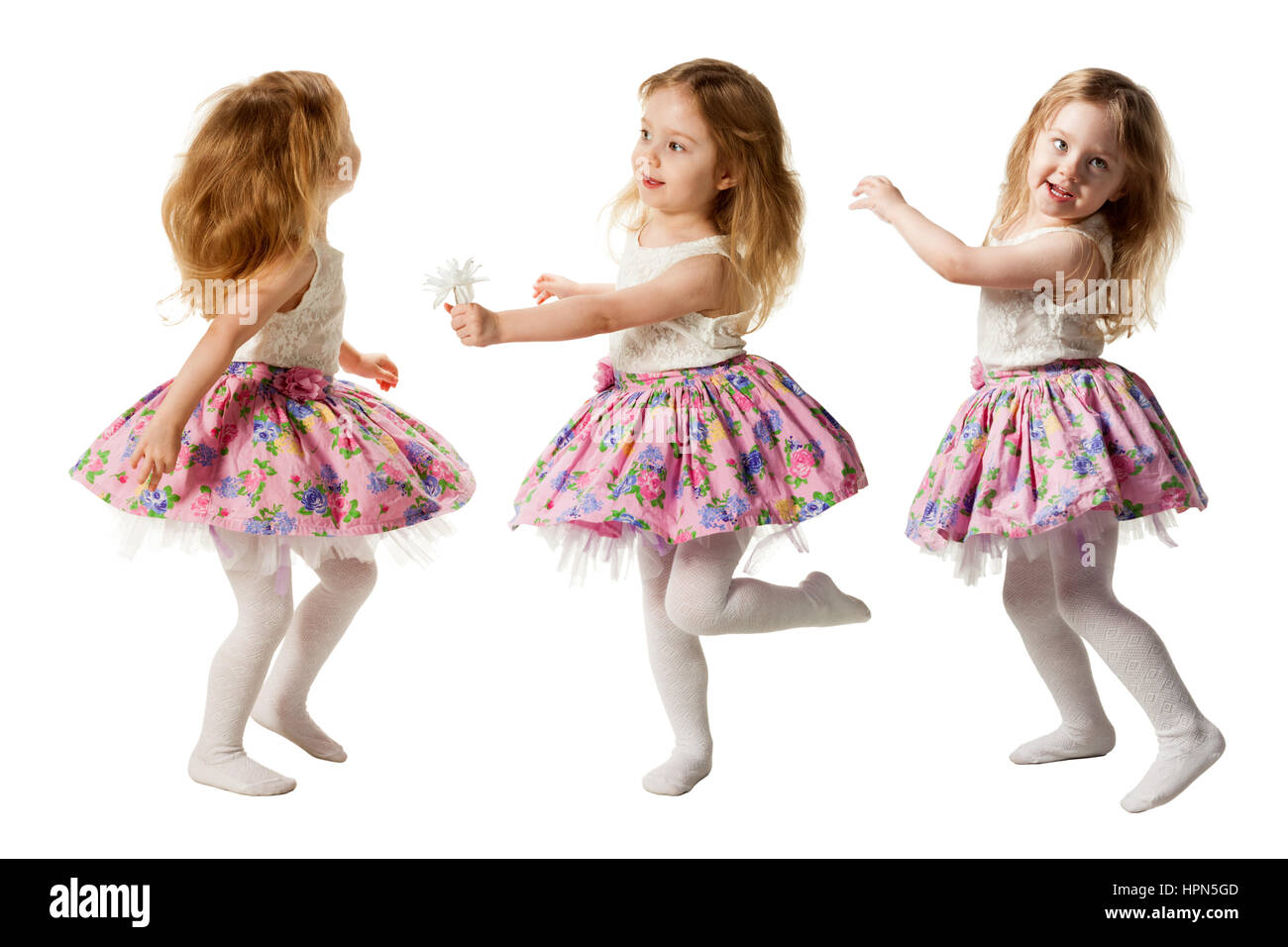 Carino tre-anno girl jumping con gioia isolati su sfondo bianco Foto Stock
