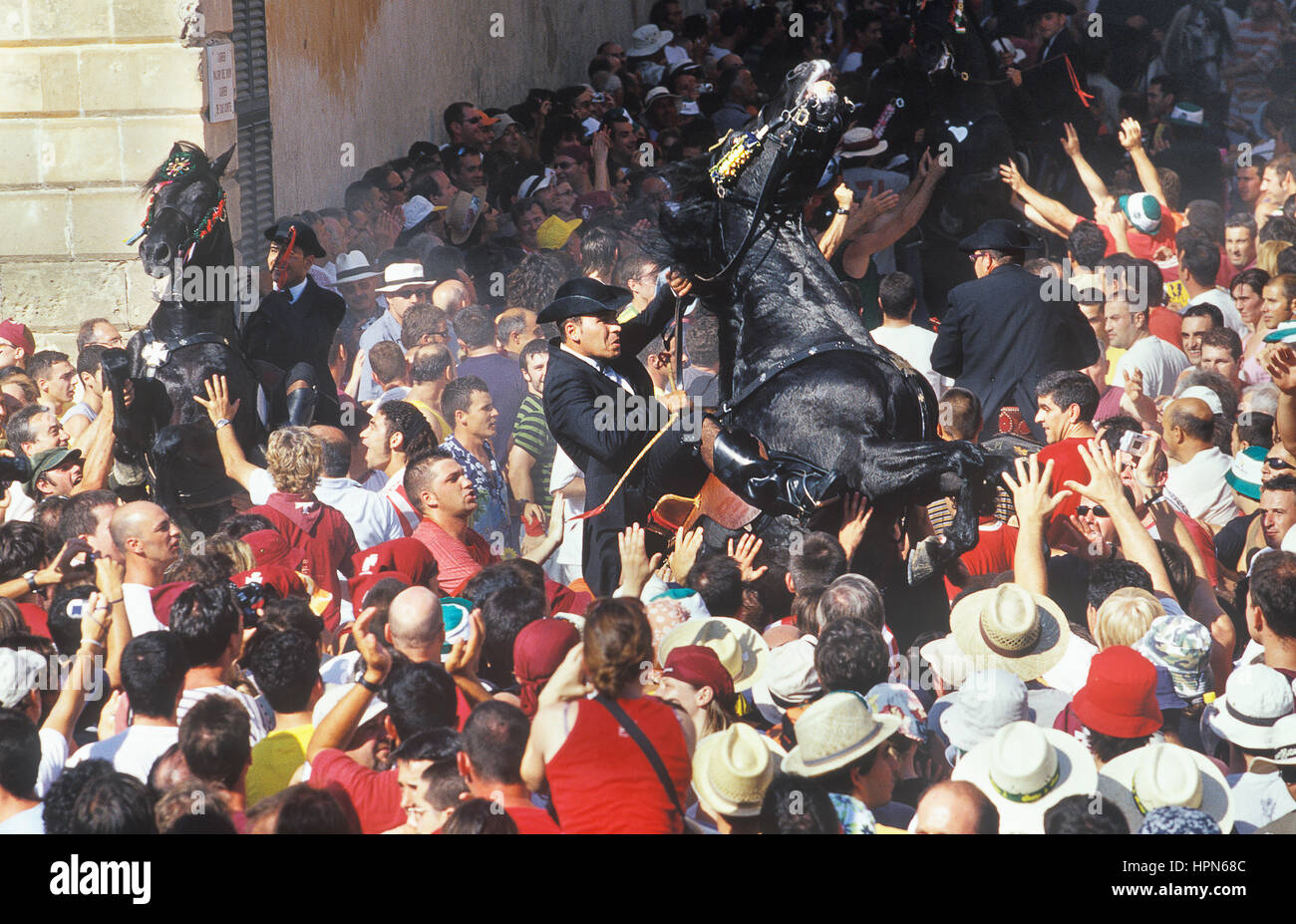 Piloti su un allevamento di cavalli tra la folla, St.John festival, Ciutadella, Minorca, Isole Baleari, Spagna Foto Stock