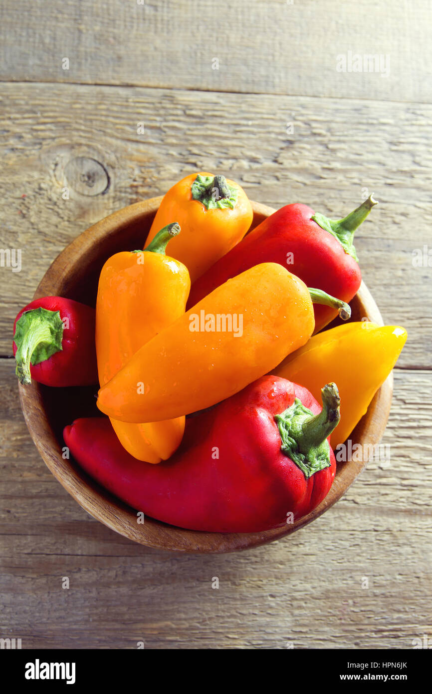 Freschi organici dolci peperoni su sfondo di legno con copia spazio - sano cibo crudo ingrediente Foto Stock