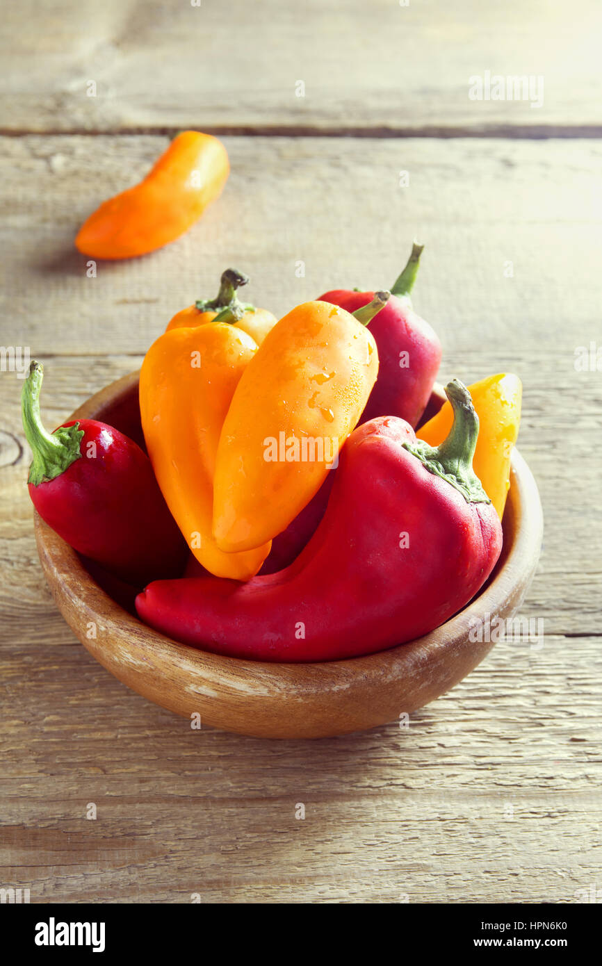 Freschi organici dolci peperoni su sfondo di legno con copia spazio - sano cibo crudo ingrediente Foto Stock