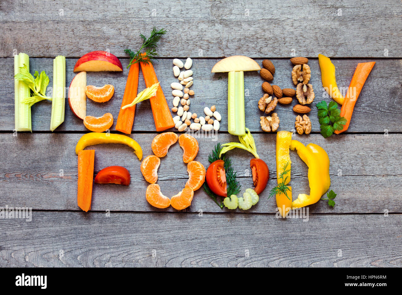 Parole "Cibo sano' scritto con ortaggi e legumi, frutta e legumi su legno rustico sfondo, concetto - ingredienti biologici per un sano vegane di Foto Stock
