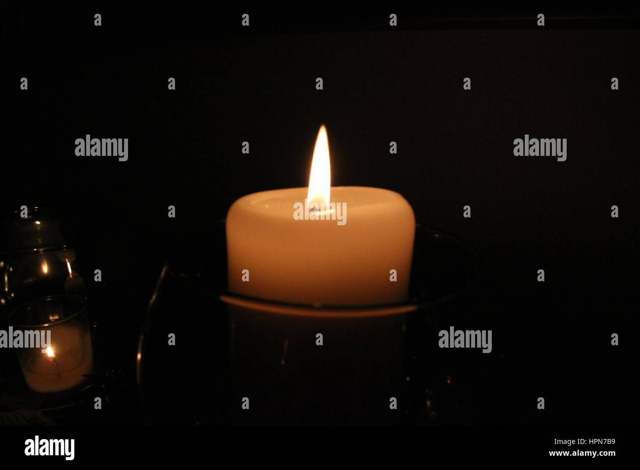 candela che brucia su sfondo scuro Foto Stock