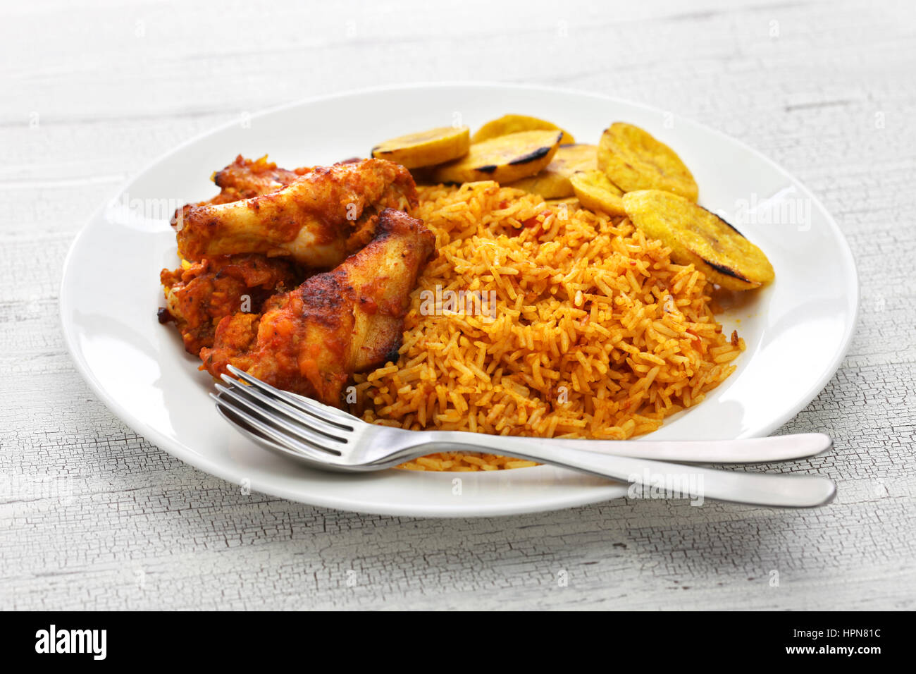 Jollof di riso con pollo fritto e piantaggine, west cucina africana Foto Stock