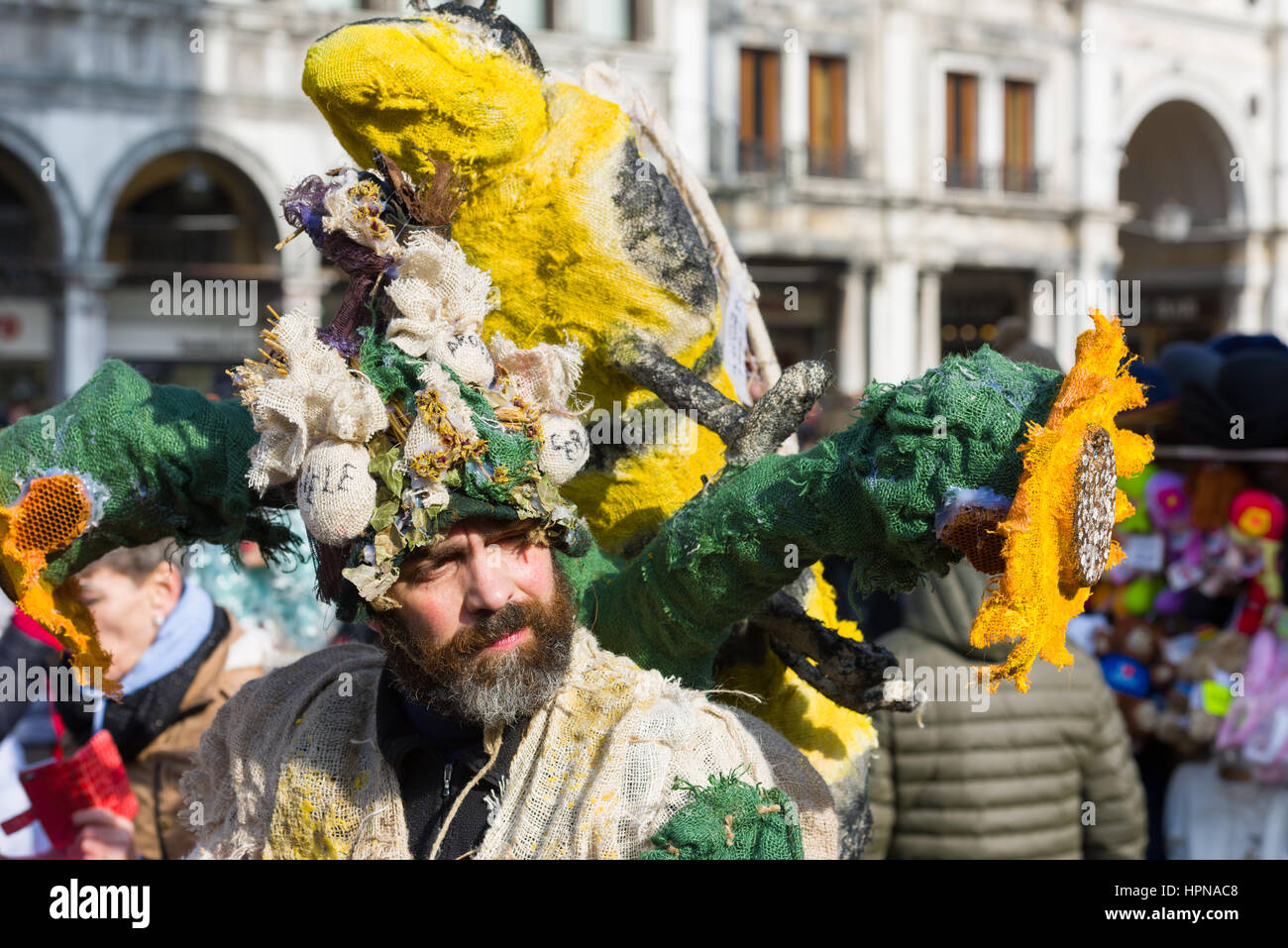 Un uomo è visto a piedi attraverso la Piazza San Marco in un costume depciting un'ape e il girasole, durante il 2017 Venezia Carrnival Foto Stock