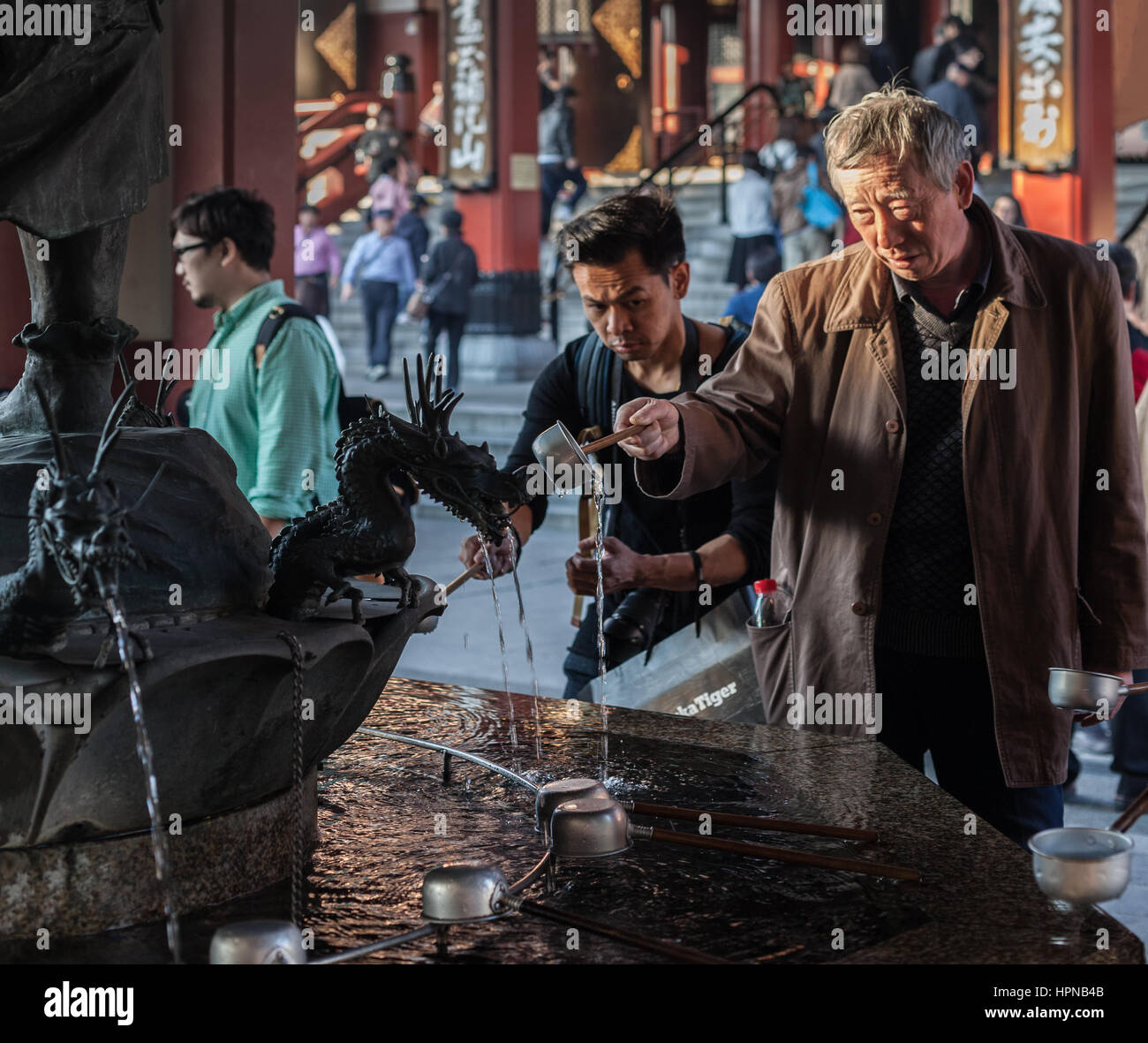 Tokyo, Giappone - 6 novembre 2015. Fontana con Dragon's statue. La gente la pulizia delle mani e acqua potabile in purificazione prima di entrare Sensoji Temp Foto Stock