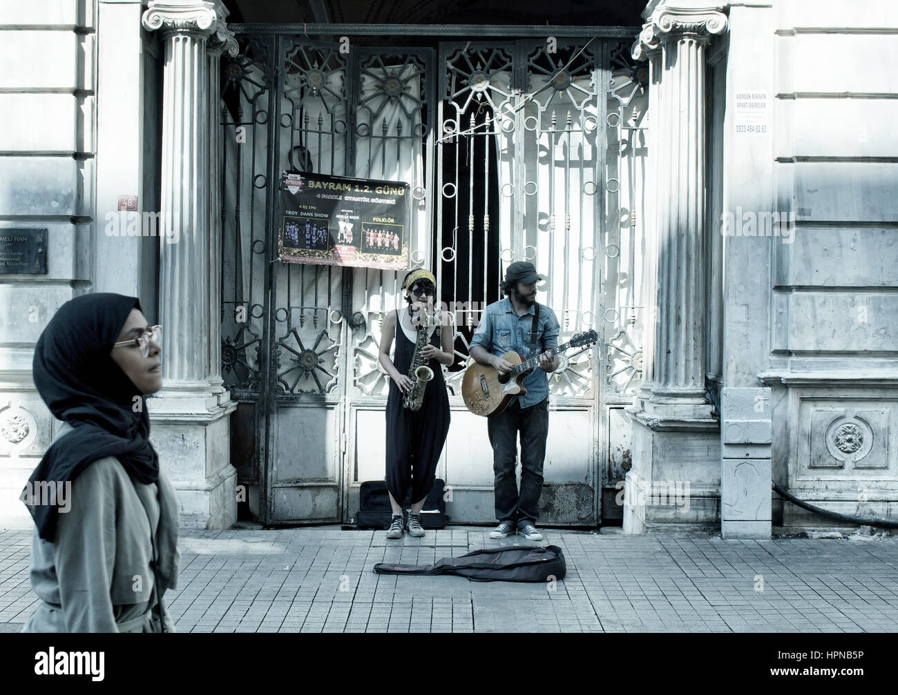 Street jazz musicians (donna e uomo) svolgono un sassofono e chitarra nella parte anteriore di uno storico edificio sul viale Istiklal in Beyoglu Istanbul. L'arabo Foto Stock