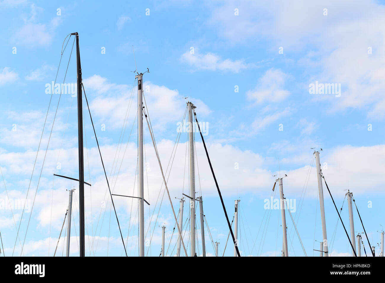 Alberi di barche a vela nel cielo blu sullo sfondo Foto Stock