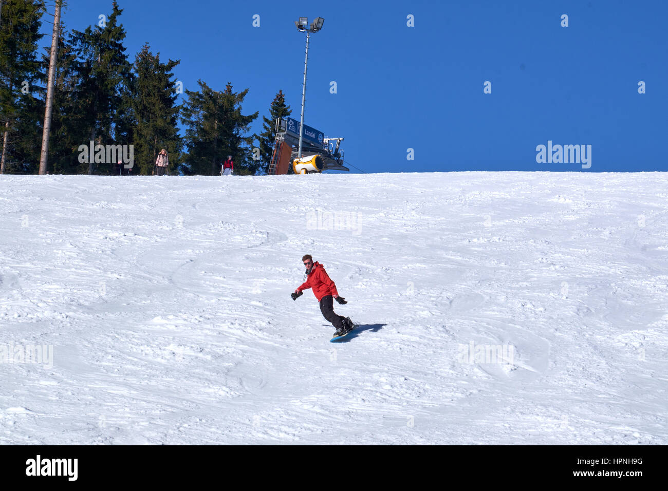 WINTERBERG, Germania - 15 febbraio 2017: uomo su snowboard sulla sua strada giù per una pista a carosello sciistico Winterberg Foto Stock