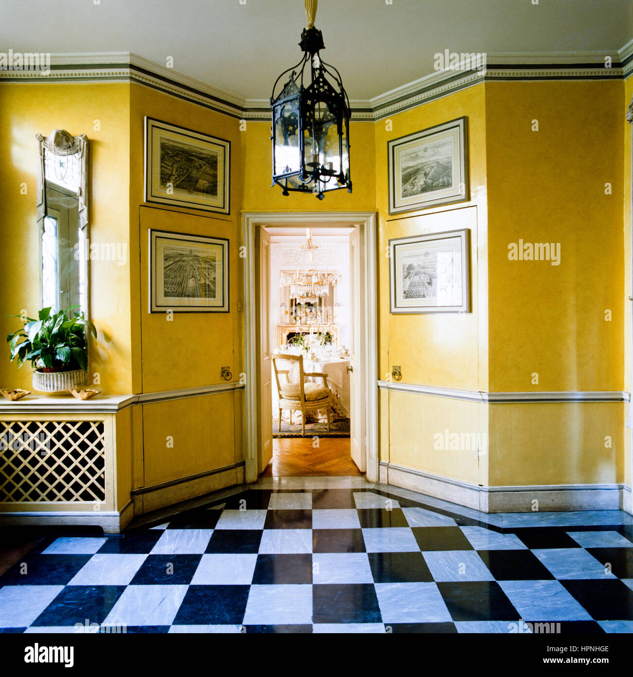 Un corridoio con pareti gialle e pavimento a scacchi. Foto Stock
