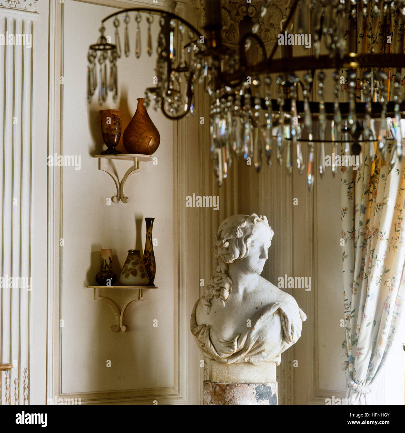 Una scultura di una donna e di scaffali di vasi antichi. Foto Stock