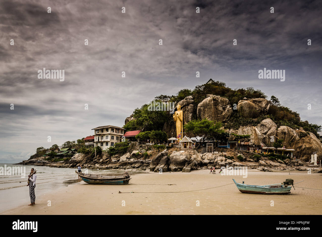 Una donna che guarda il mare su Khao Takiab spiaggia di Hua Hin. Nella parte anteriore è il tempio alla fine della spiaggia. Questa è la parte più tranquilla di Hua Hin. Foto Stock