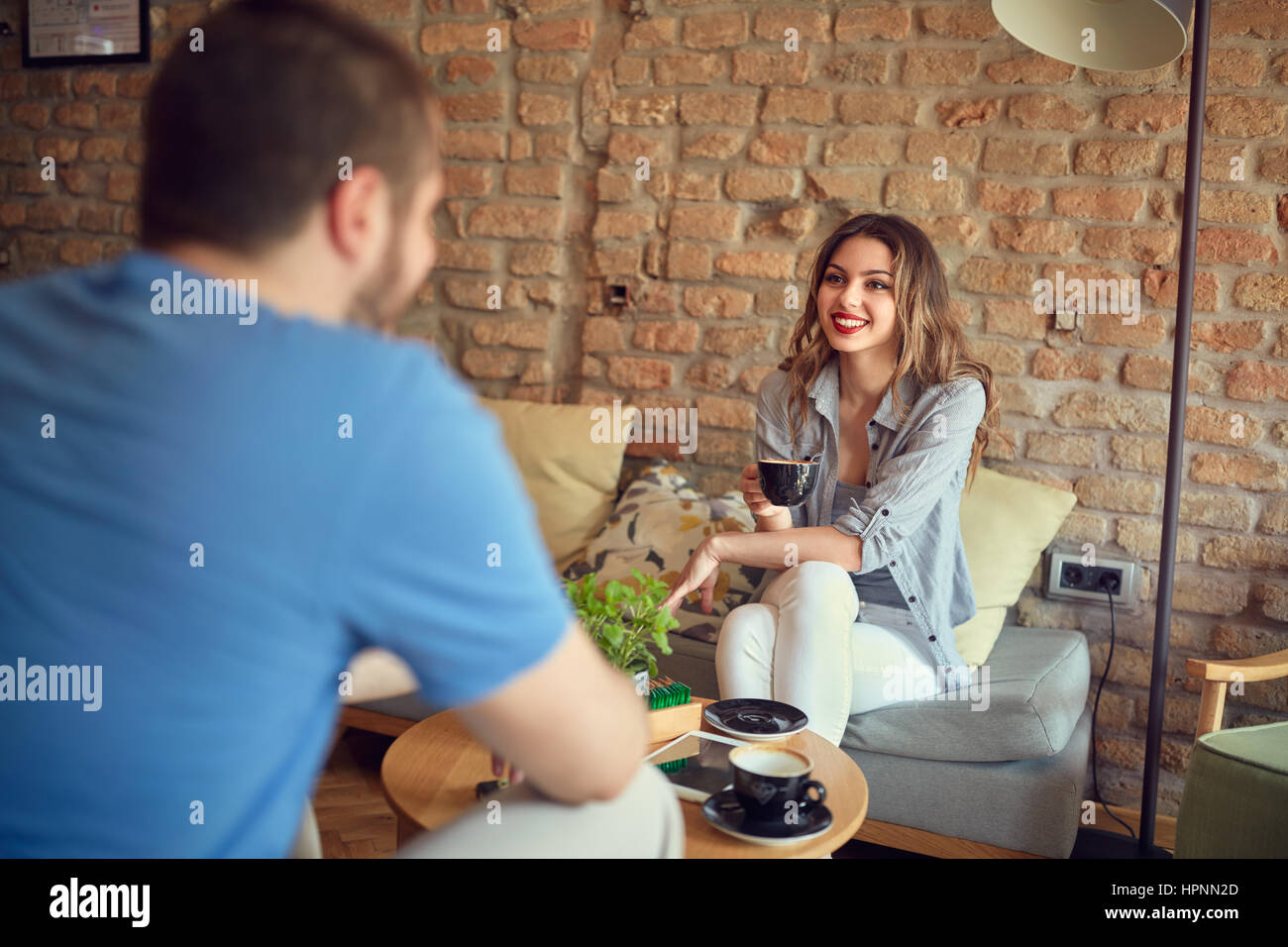 Giovane donna con un amico in pub moderno Foto Stock