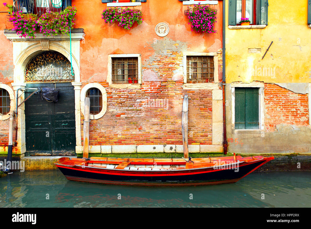 Barca vicino alla vecchia casa in stretto canale di Venezia Foto Stock