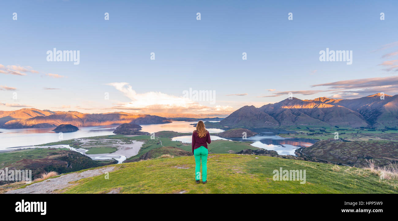 Tramonto, escursionista affacciato sul lago Wanaka, picco roccioso, picco roccioso Park, Otago Southland, Nuova Zelanda Foto Stock
