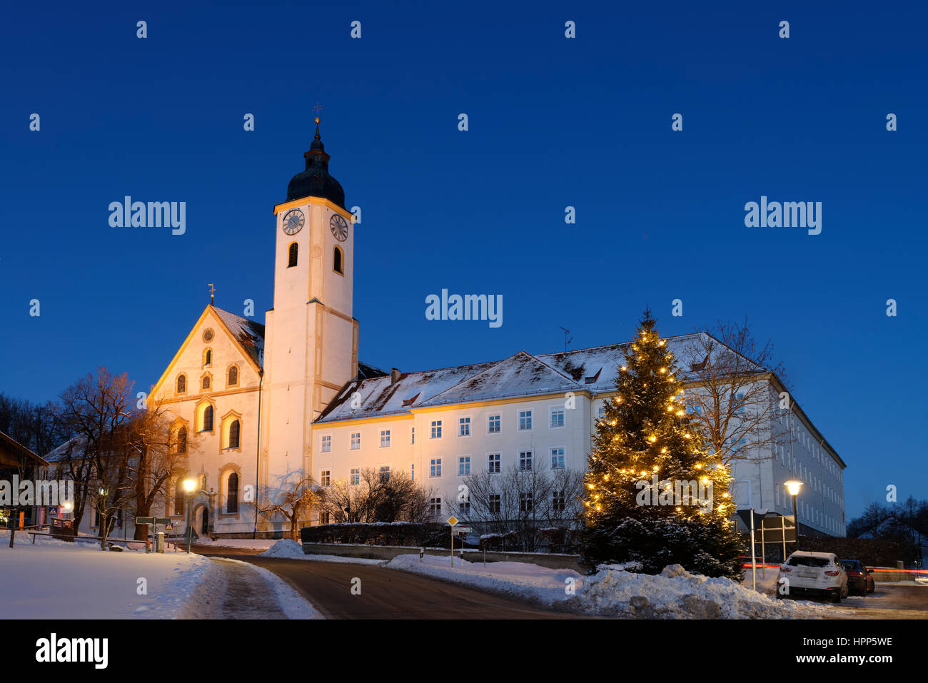 Illuminato albero di Natale nella parte anteriore del monastero chiesa Dietramszell, crepuscolo, Alta Baviera, Baviera, Germania Foto Stock