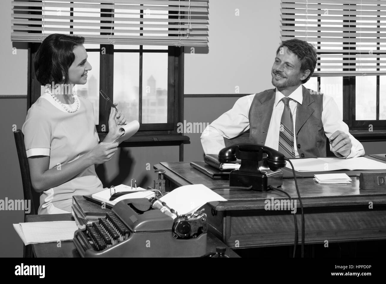 Direttore e segretario lavorando insieme alla scrivania, anni cinquanta ufficio stile . Foto Stock