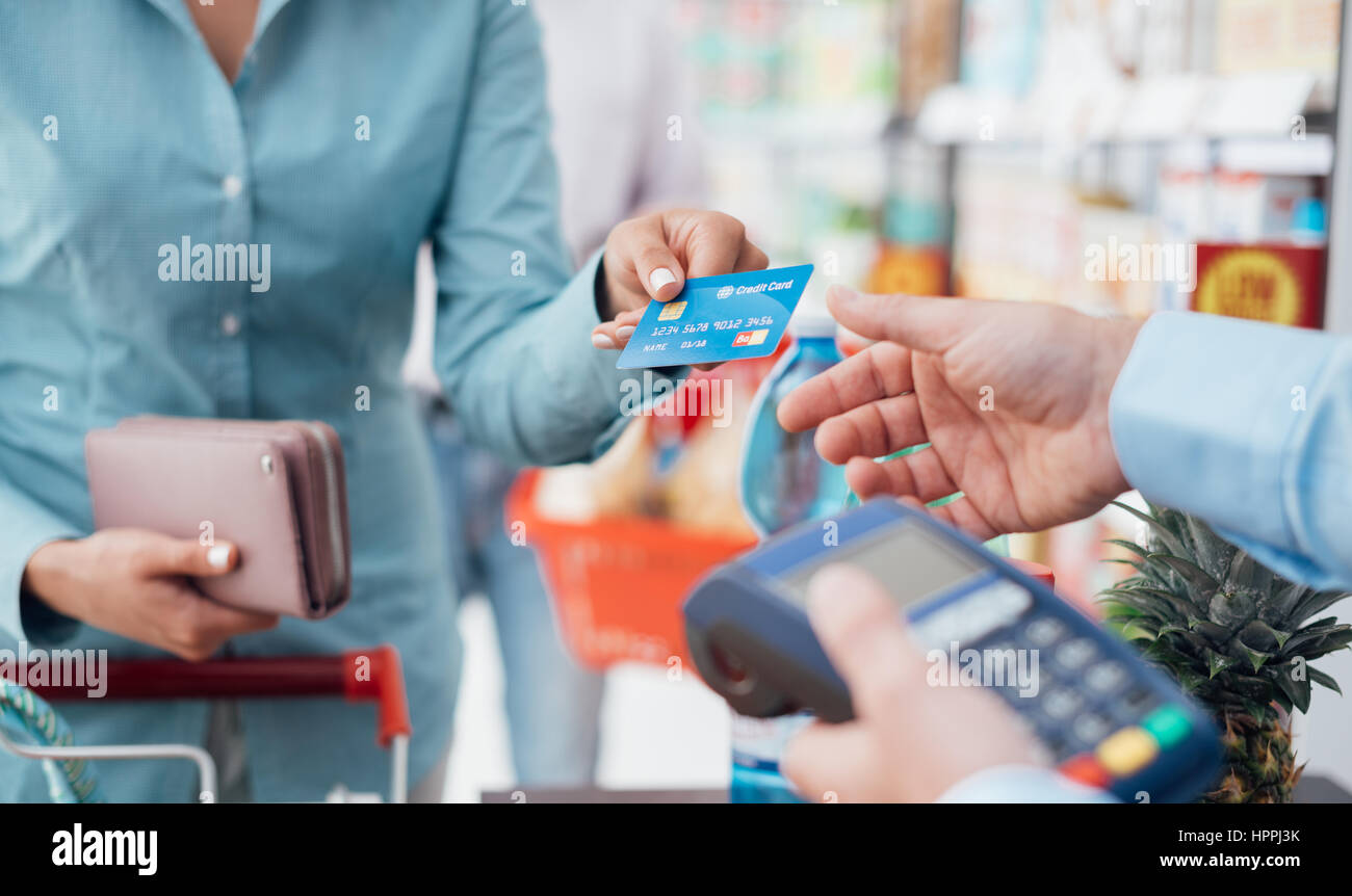 Donna al supermercato checkout, ella è di pagare con una carta di credito, dello shopping e del concetto di vendita al dettaglio Foto Stock