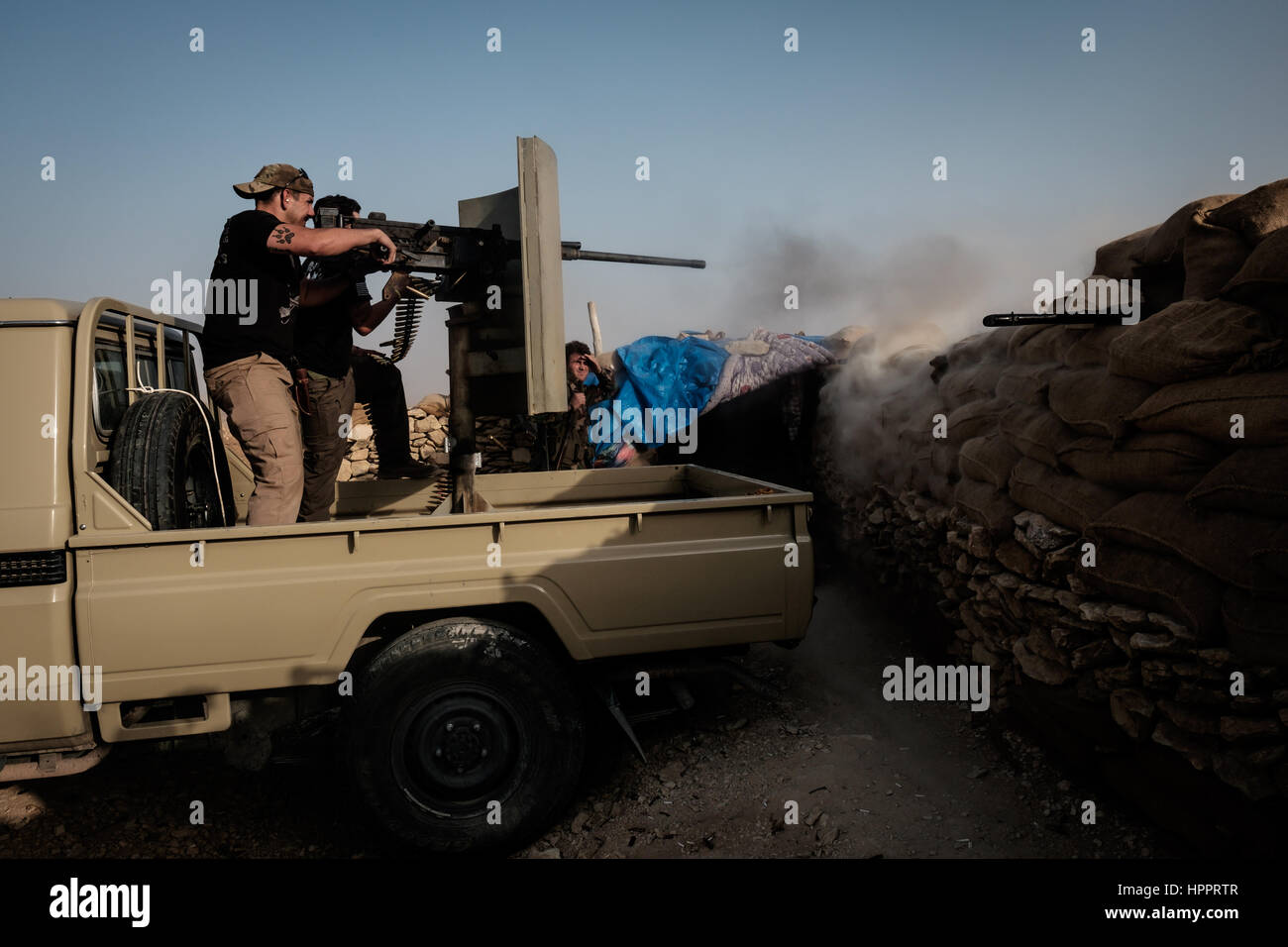 Giosuč e James Martinez innestare uno stato islamico con obiettivi a catturato Browning 50 caliber Machine Gun da una posizione di combattimento guardando oltre Sinjar Foto Stock