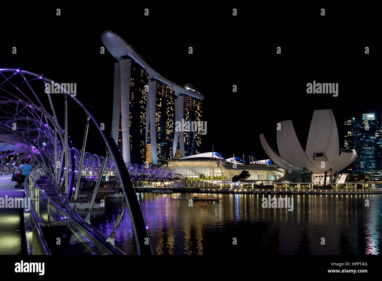 Una vista della MBS - Marina Bay sands hotel e complesso di Helix bridge in notturna a Singapore. Foto Stock