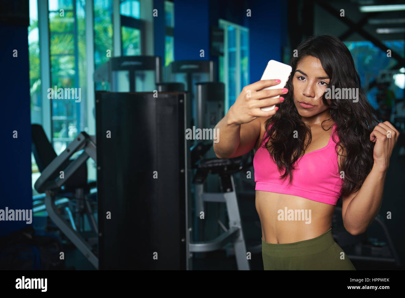 Donna prendere selfie nel fitness club background dopo esercizio. Bella donna sportivo prendere auto foto in palestra Foto Stock
