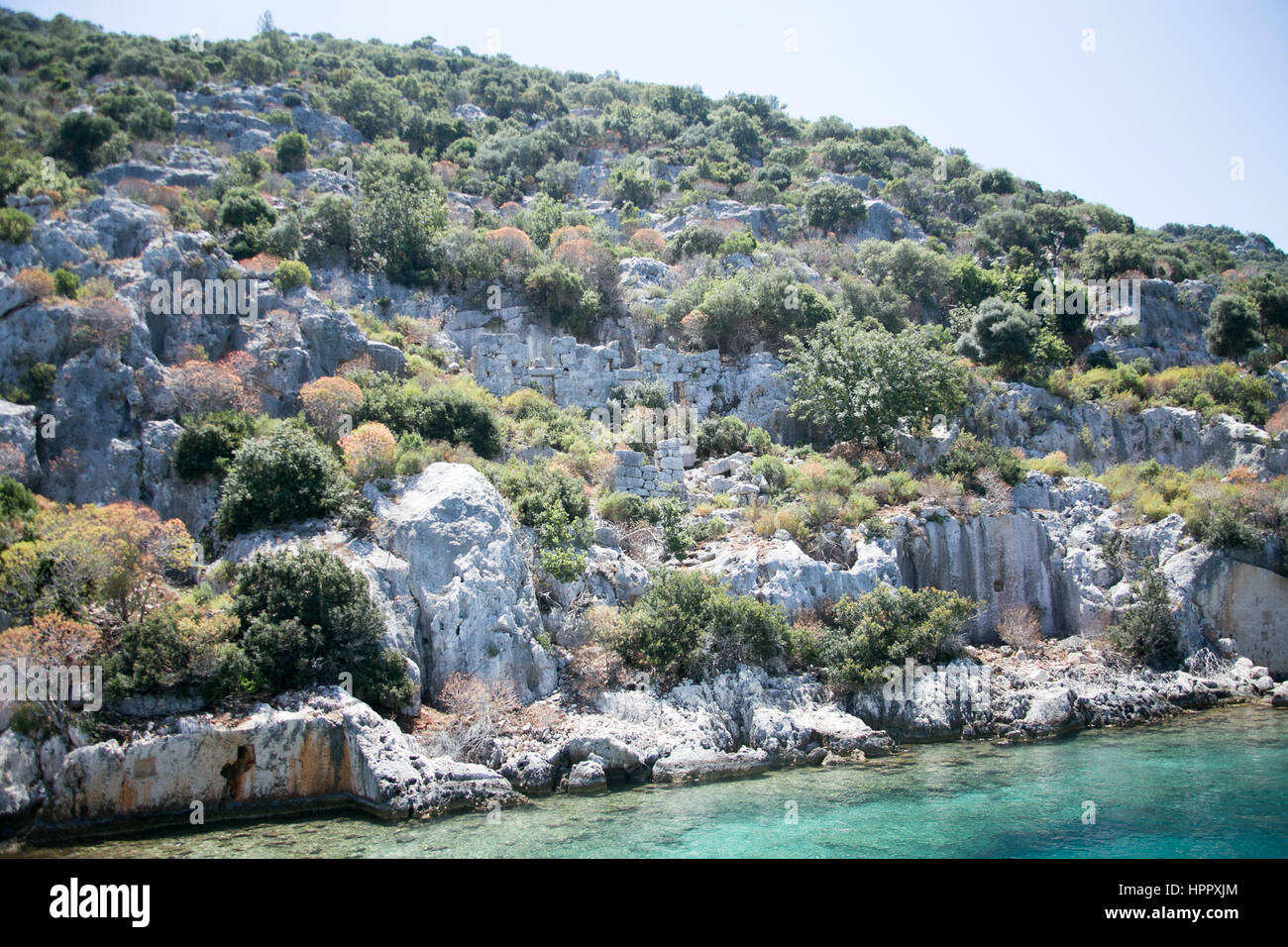 Città Sommersa di kekova nella baia di uchagiz vista dal mare in provincia di Antalya in Turchia con turqouise rocce del mare e il verde delle boccole con resti di antichi Foto Stock