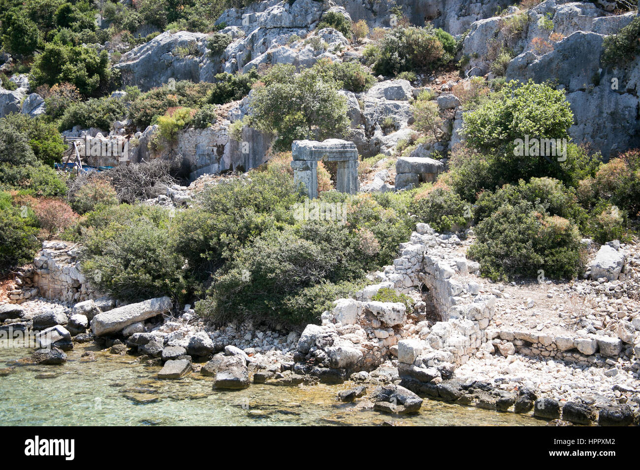 Città Sommersa di kekova nella baia di uchagiz vista dal mare in provincia di Antalya in Turchia con turqouise rocce del mare e il verde delle boccole con resti di antichi Foto Stock