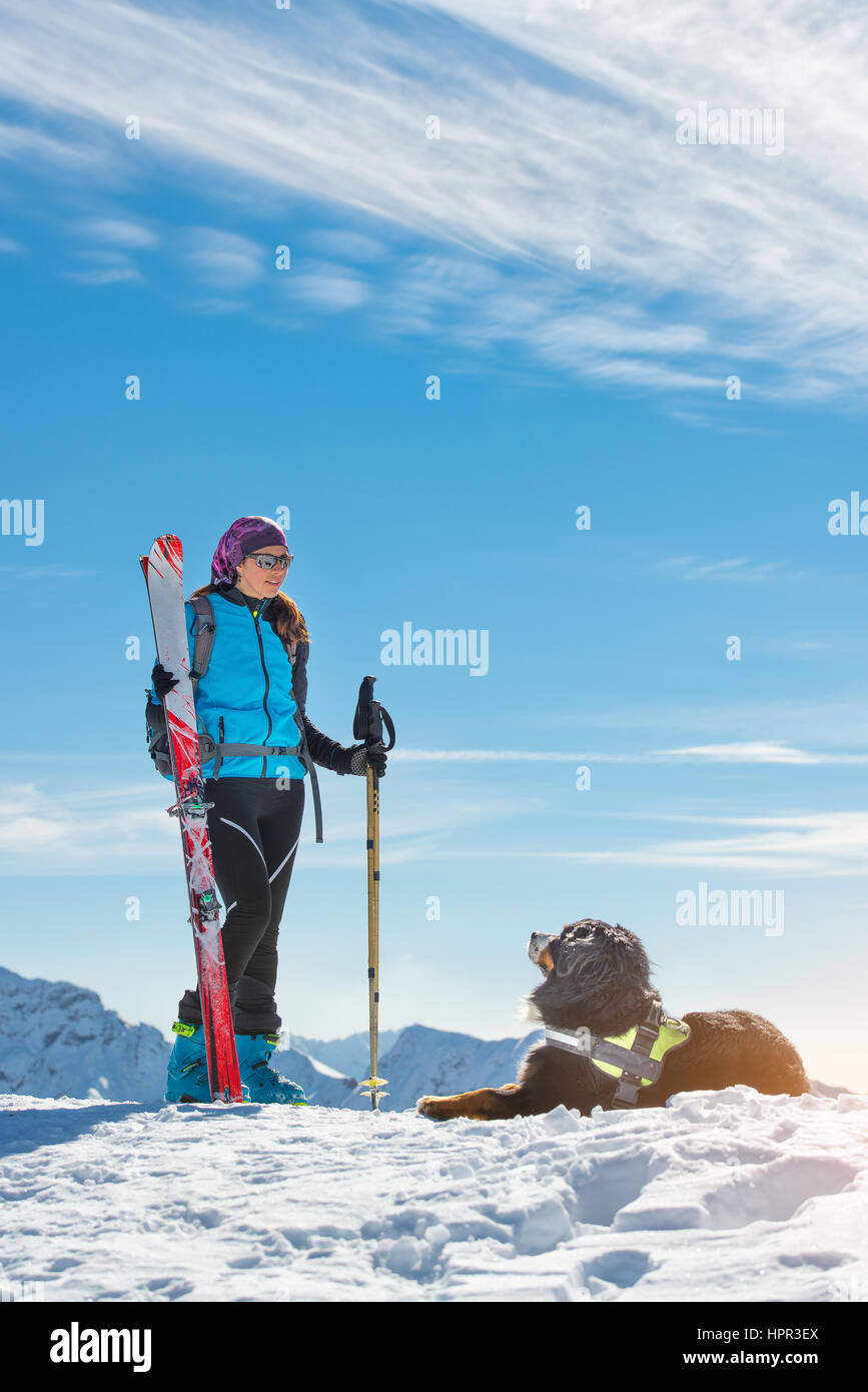 Bernese cane in montagna nella neve con maestra di sci alpino Foto Stock