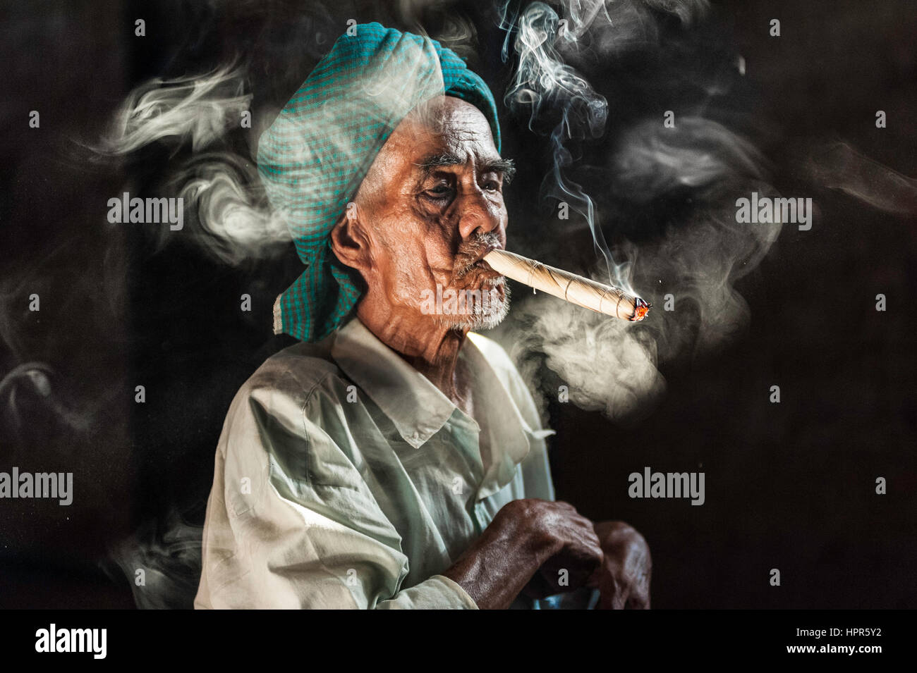 Ritratto di un uomo birmano con un tipico fazzoletto sulla sua testa di  fumare un sigaro di grande fatta di tabacco e foglie di mais Foto stock -  Alamy