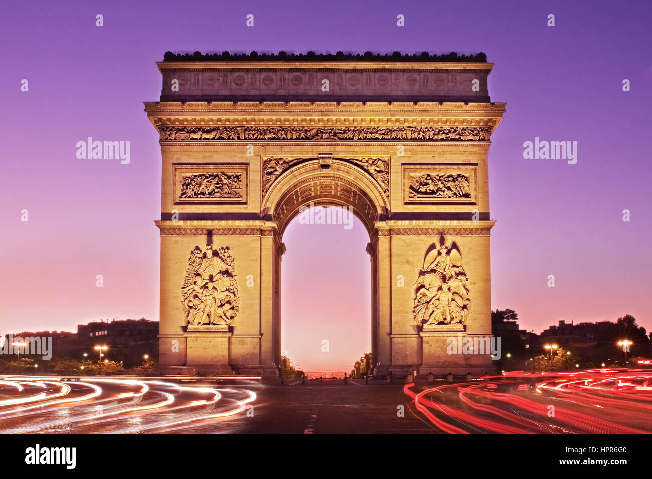 Un alba vista del Arc de Triomphe presi dall'Avenue de la Grande Armée. La luce percorsi di traffico portano a e intorno al monumento storico. Foto Stock