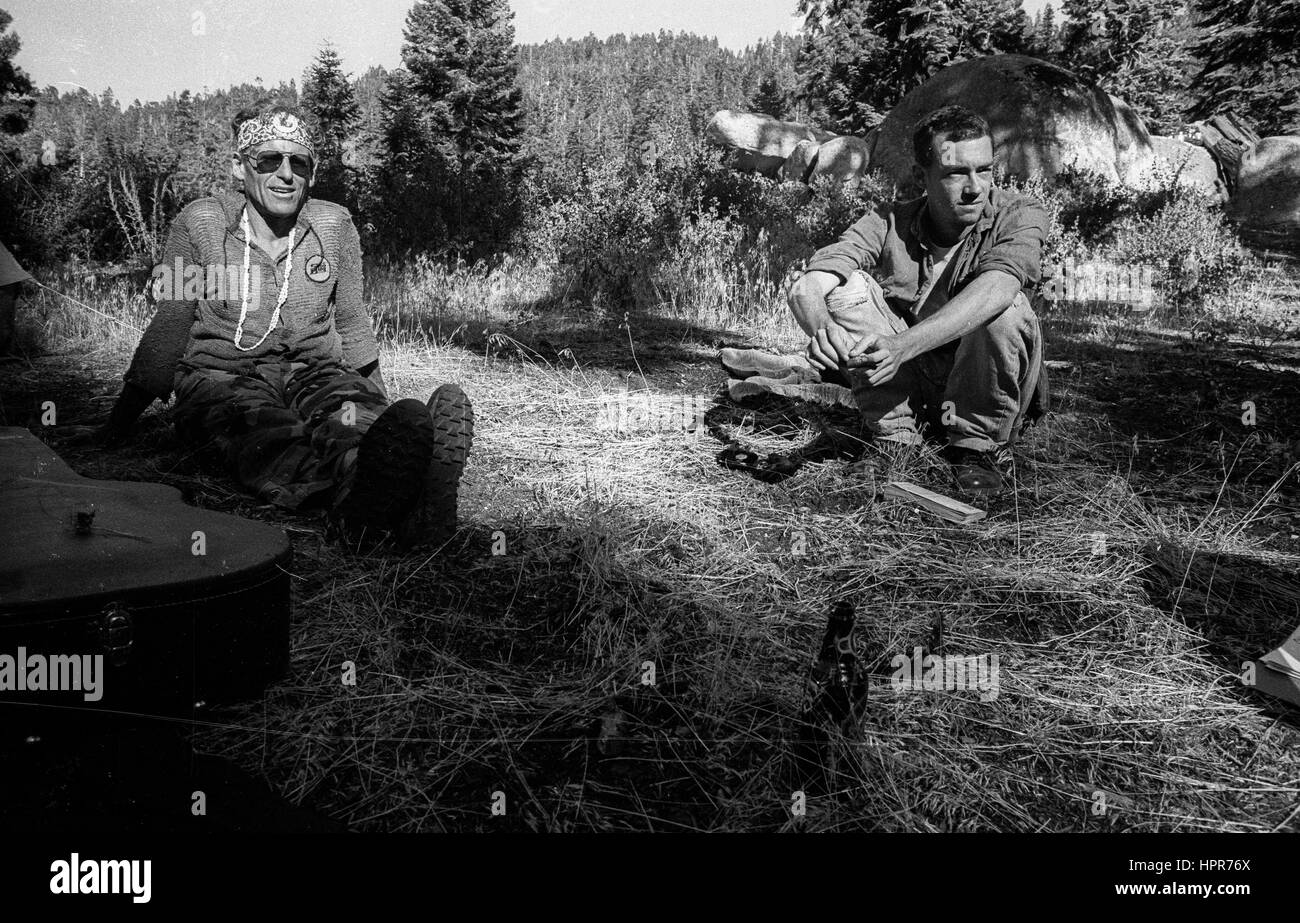 Messa a terra per primo! Redwood Estate. Sequoia National Forest. 1989 Due uomini seduti su una strada il giorno prima di una protesta contro la registrazione durante gli anni di Reagan. Una sezione della foresta era stato chiaro. Foto Stock