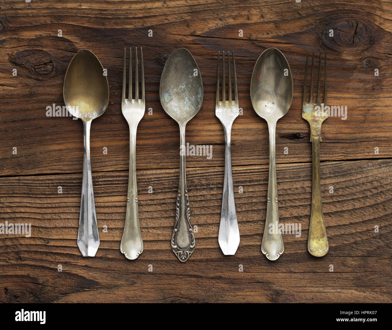 Vecchio forchette e cucchiai su sfondo di legno Foto Stock