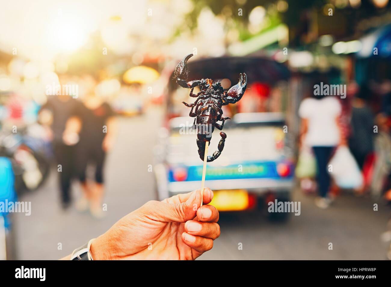 La mano del produttore thailandese che mostra arrosto di scorpione. Strada del mercato nel centro di Bangkok, Tailandia. Foto Stock