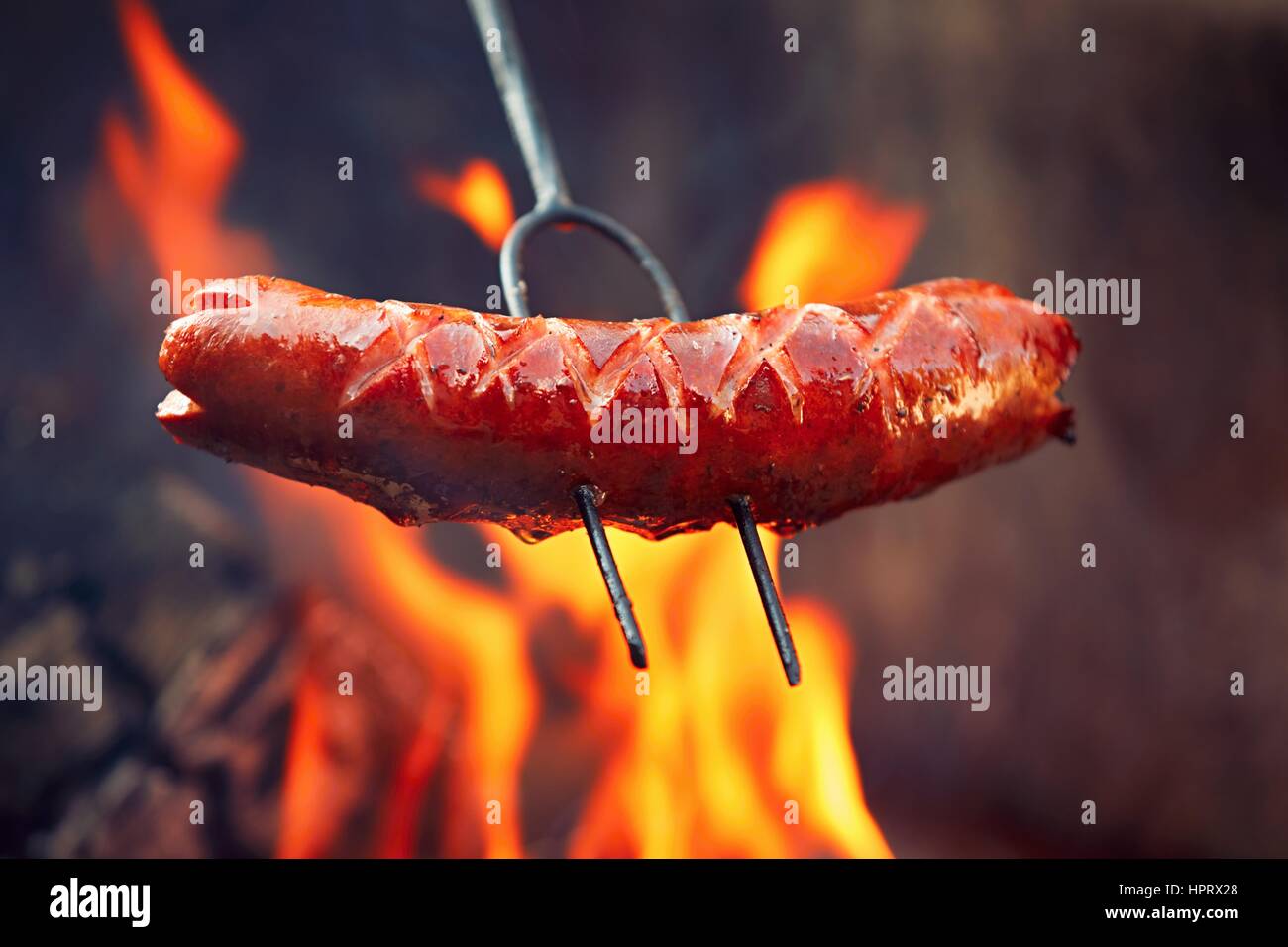 Salsicce oltre l'bondfire in natura - il fuoco selettivo Foto Stock