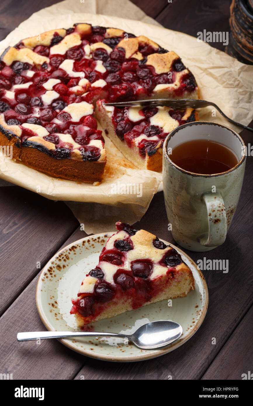 In casa torta di ciliegie con tazza da tè sul tavolo di legno. Foto Stock