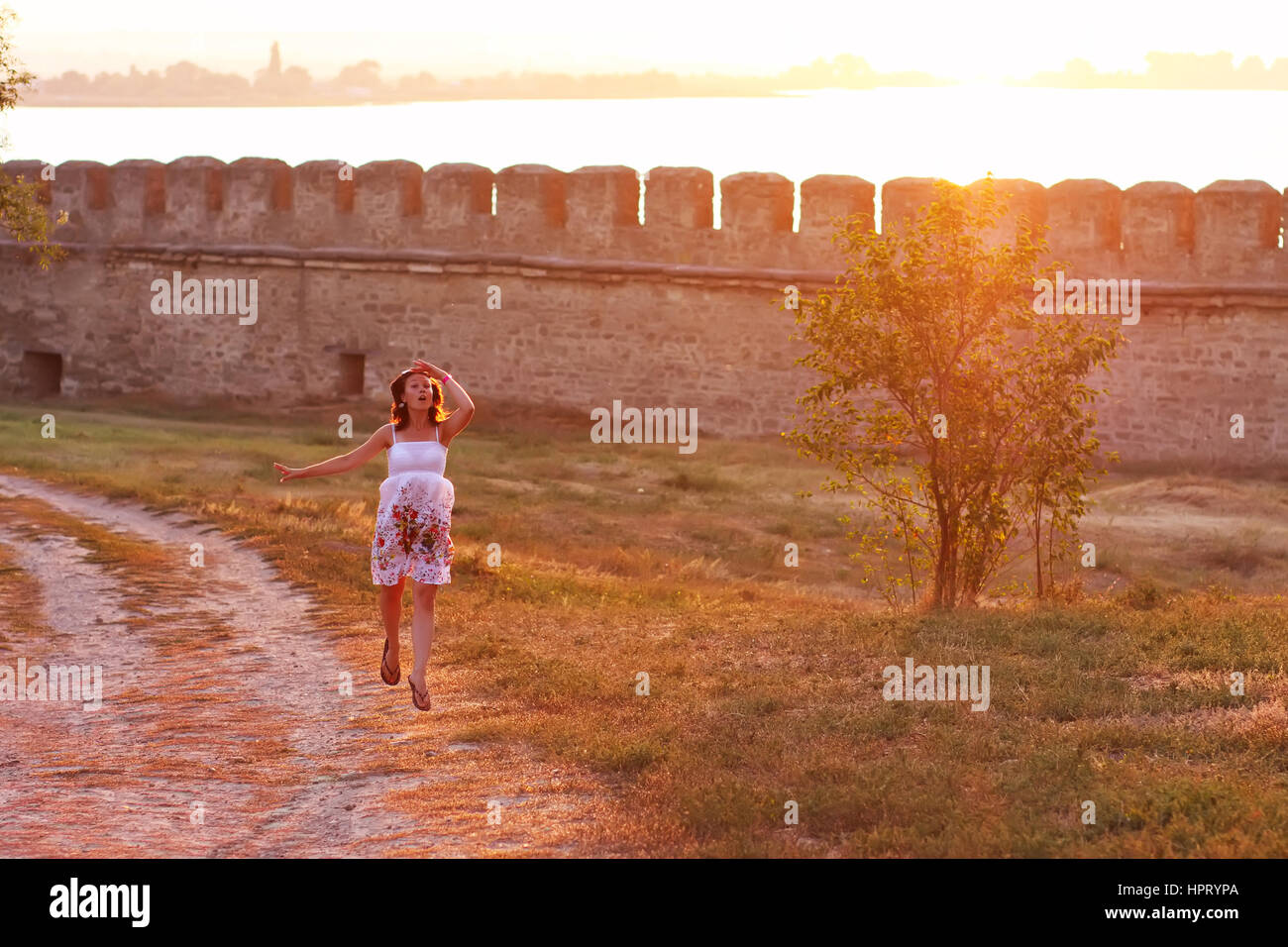 Ragazza giovane cercando la felicità dei colori del tramonto Foto Stock