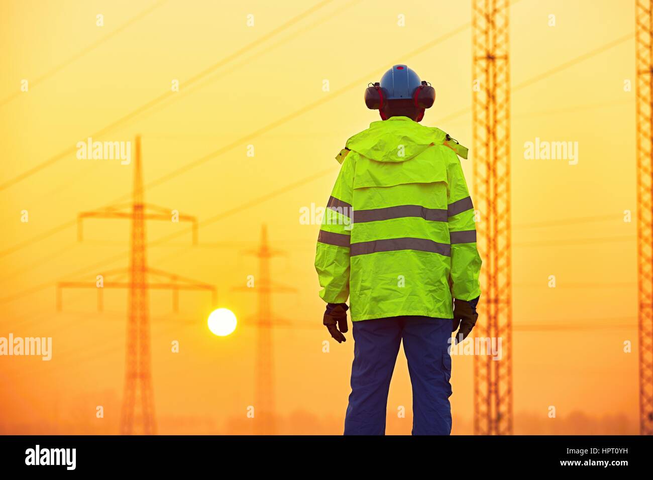 Lavoratore è la visione di piloni di elettricità e sottostazione al sunrise Foto Stock