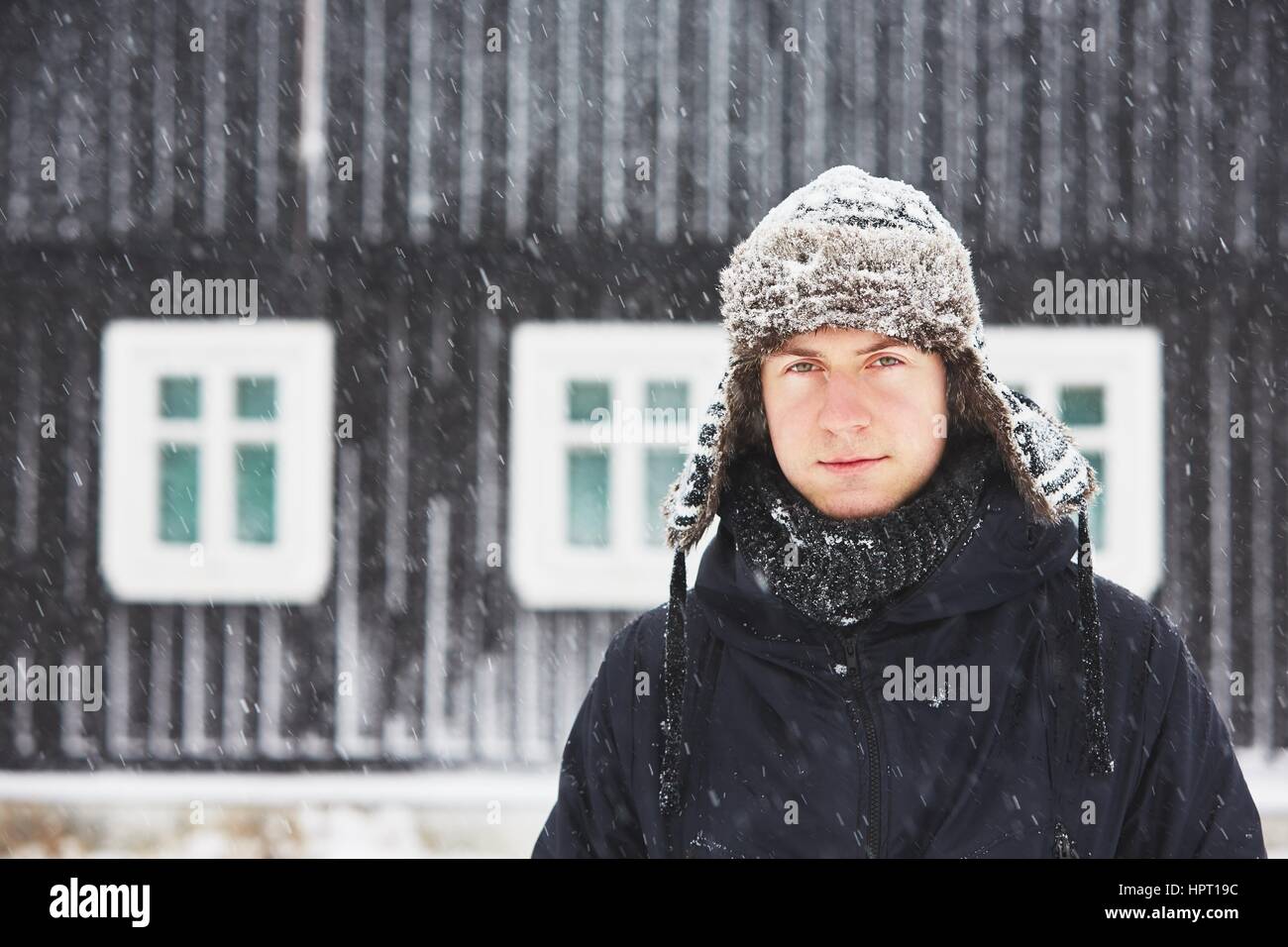 Ritratto di giovane uomo all'aperto in inverno sotto la tempesta di neve Foto Stock