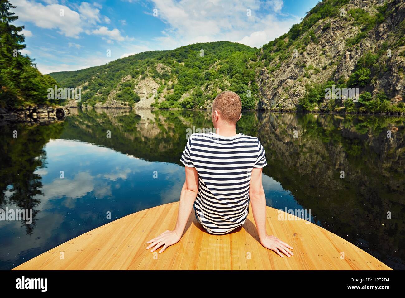 Viaggio sul Fiume. Uomo bello è seduto sulla prua della barca. Il fiume Moldava vicino a Praga, Repubblica Ceca Foto Stock