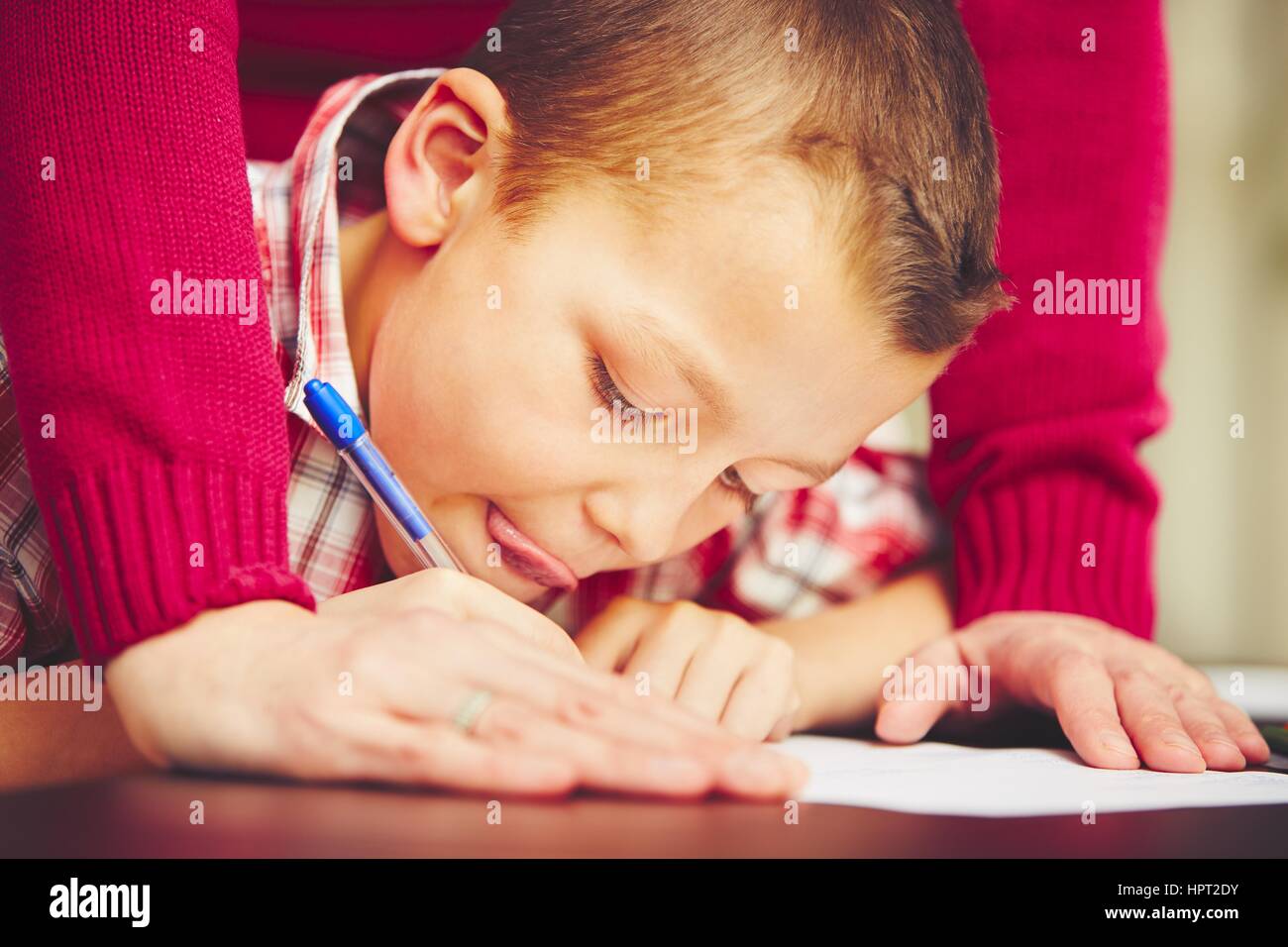 Little Boy sta facendo i suoi compiti per la scuola elementare. Foto Stock