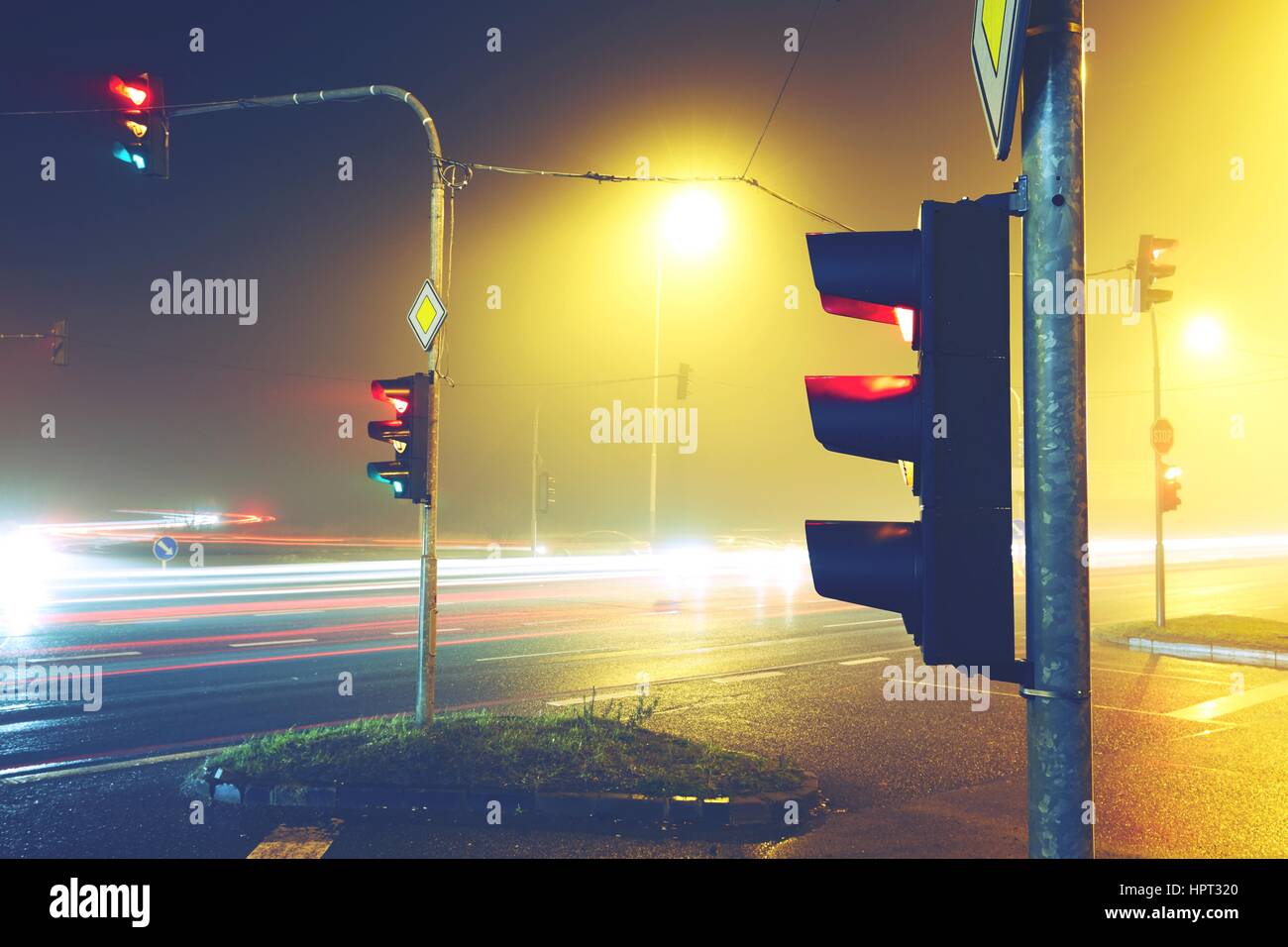 Semaforo - bivio nella notte di nebbia Foto Stock