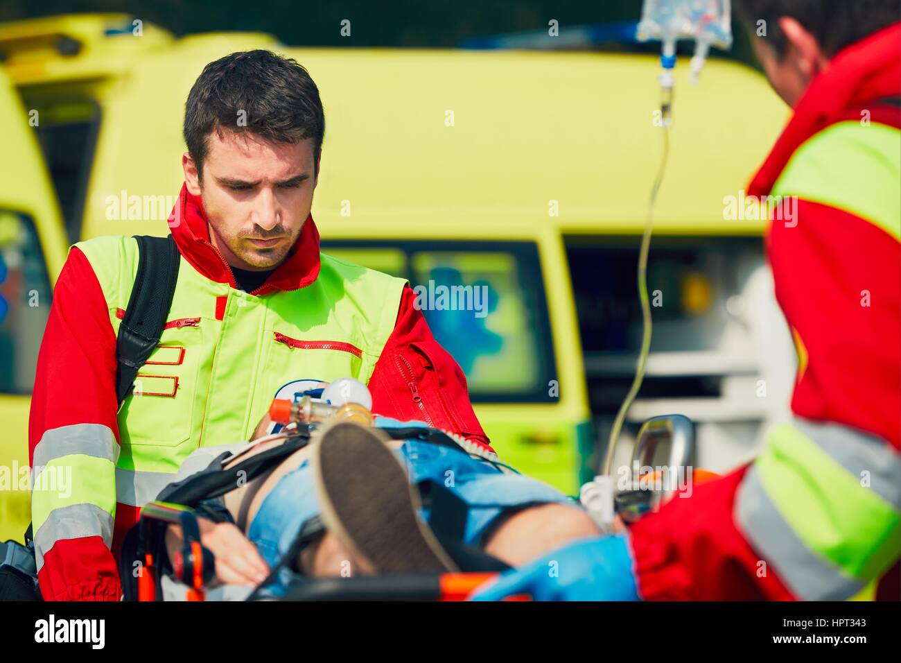 Team di soccorritori (personale paramedico e medico) preparazione del paziente dopo la rianimazione per il trasporto in ospedale. Foto Stock