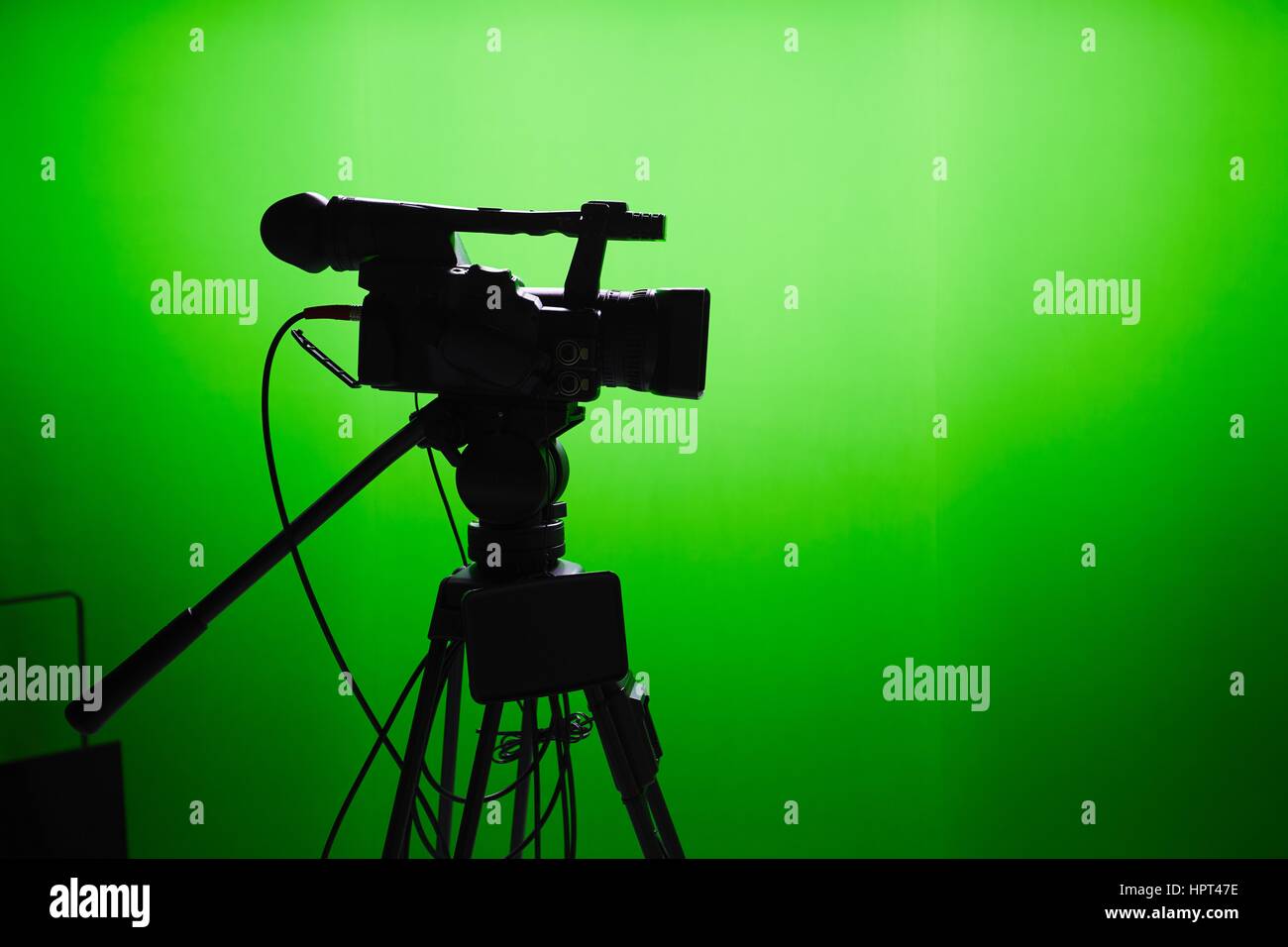 Silhouette di videocamera digitale davanti allo schermo verde Foto Stock