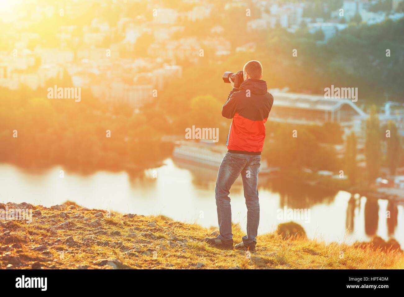 Mattina di ripresa fotografica. Fotografo con specchio telecamera tenendo la foto del sorprendente sunrise. Foto Stock